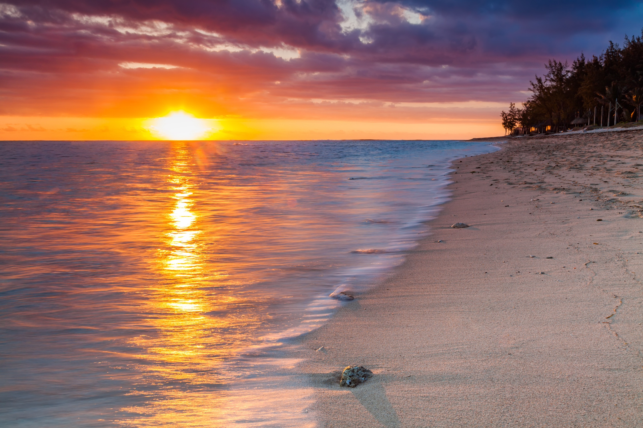 Beautiful sunset on the beach in a tropical resort at Reunion island.